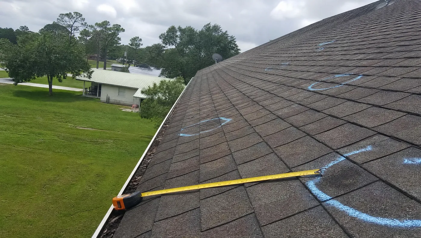 Hail bruising marked in chalk on a shingle roof in Brazoria County Texas